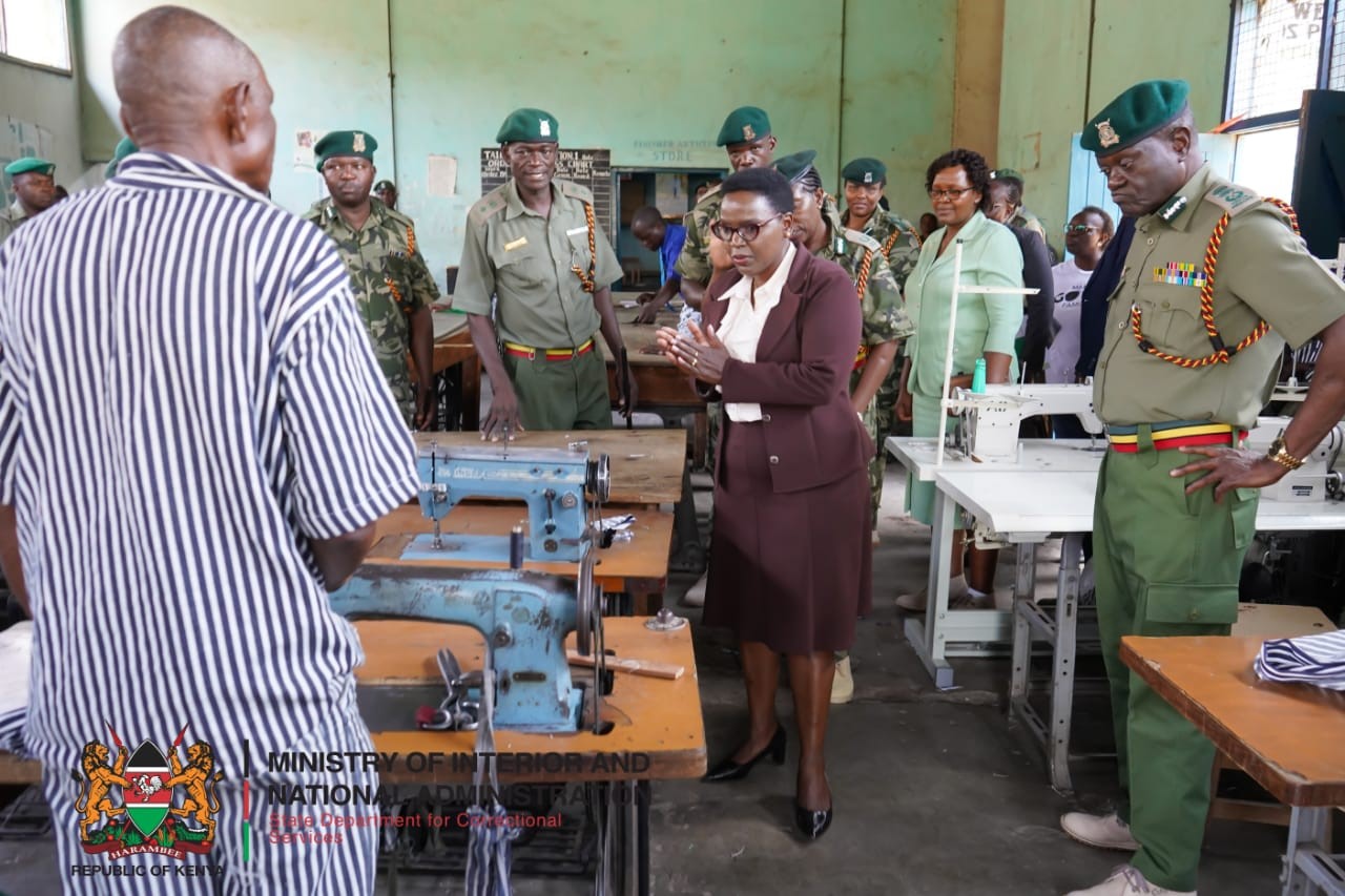 Correctional Services PS Ms. Salome M. Beacco addresses an inmate at the Kibos Maximum Security tailoring workshop. She was accompanied by Commissioner General of Prisons Brg (Rtd) John Warioba (on her left) and Director Probation and Aftercare Services Christine Obondi. Among other officers from the State Department. Photo: Patrick Ambani.