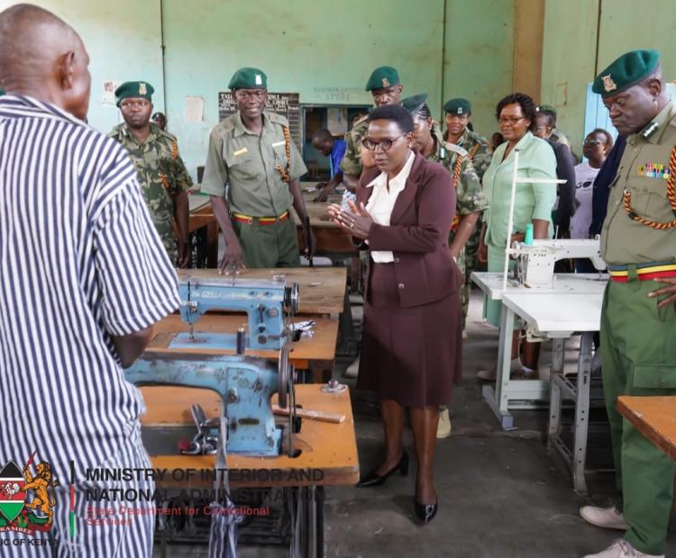 Correctional Services PS Ms. Salome M. Beacco addresses an inmate at the Kibos Maximum Security tailoring workshop. She was accompanied by Commissioner General of Prisons Brg (Rtd) John Warioba (on her left) and Director Probation and Aftercare Services Christine Obondi. Among other officers from the State Department. Photo: Patrick Ambani.